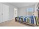 A bedroom features a window, a bathroom, and a bed with colorful striped bedding at 738 Harrison Mill St., Myrtle Beach, SC 29579