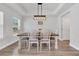 Light-filled dining room with tray ceiling, stylish light fixture, and a neutral color palette with wood flooring at 738 Harrison Mill St., Myrtle Beach, SC 29579