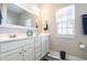 Bright bathroom with double sink vanity, white cabinets, and a large mirror at 768 Satterwhite Way, Myrtle Beach, SC 29577