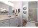 Well-lit bathroom featuring double sinks, decorative mirrors, and a glass door shower at 768 Satterwhite Way, Myrtle Beach, SC 29577