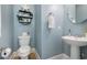 Stylish powder room with blue walls, pedestal sink, and decorative accents at 768 Satterwhite Way, Myrtle Beach, SC 29577