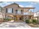 Exterior front elevation of a raised beach home with a spacious carport and stairs to the covered porch at 813 Starboard Ct., Murrells Inlet, SC 29576