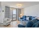 Cozy living room with a plush blue sofa, stylish curtains, and ample natural light from the balcony at 8560 Queensway Blvd. # 1206, Myrtle Beach, SC 29572