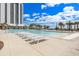 Resort-style pool with lounge chairs and palm trees on a sunny day at 8560 Queensway Blvd. # 1206, Myrtle Beach, SC 29572