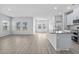 Open-concept living space with modern kitchen featuring an island, stainless appliances, and luxury vinyl flooring at 8704 High Banks Way, Longs, SC 29568