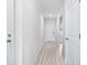 Bright hallway featuring light wood flooring, white walls, and white doors leading to various rooms at 8720 High Banks Way, Longs, SC 29568