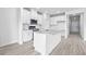 Modern kitchen with white cabinets, granite countertops, stainless steel appliances, and wood-look floors at 8720 High Banks Way, Longs, SC 29568