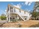 Elevated coastal home boasting a screened porch, easy-access stairs, and ample ground-level parking at 939 Tiffany Ln., North Myrtle Beach, SC 29582