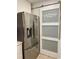 Stainless steel refrigerator with water dispenser next to laundry room door and a sliding barn door at 971 Blue Stem Dr. # 41 H, Pawleys Island, SC 29585