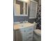 Bright bathroom with a white vanity, toilet, and a decorative mirror at 9903 Conifer Ln., Murrells Inlet, SC 29576