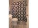 Bathroom featuring a toilet, sink with cabinet, and black and white patterned shower curtain at 9903 Conifer Ln., Murrells Inlet, SC 29576