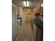 Galley kitchen featuring oak cabinets, white appliances, tile backsplash and flooring at 9903 Conifer Ln., Murrells Inlet, SC 29576