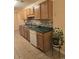 Well-lit kitchen with stainless steel sink, wood cabinets, and tile backsplash at 9903 Conifer Ln., Murrells Inlet, SC 29576