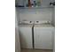Convenient laundry room with a full-sized white washer and dryer set and wire shelving at 9903 Conifer Ln., Murrells Inlet, SC 29576