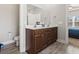 Bathroom features a dual sink vanity with wood cabinets and access to bedroom at 10015 W Highway 19, Loris, SC 29569