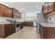 Open concept kitchen with wood cabinets, stainless appliances, granite counters, and views to living area at 10015 W Highway 19, Loris, SC 29569