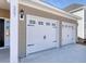 Two-car garage with white doors featuring decorative windows and hardware, complementing the tan siding and address at 1071 Laconic Dr., Myrtle Beach, SC 29588