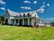 Bright, single-Gathering home featuring a covered porch, mature landscaping, and sunny curb appeal at 1083 Milford Way, Myrtle Beach, SC 29588