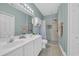 Bathroom with double sink vanity, walk-in shower, neutral tile, and decor at 1100 Commons Blvd. # 1001, Myrtle Beach, SC 29572