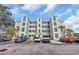 Condo building with multiple units, manicured landscaping, and ample parking on a sunny day at 1100 Commons Blvd. # 1001, Myrtle Beach, SC 29572