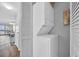 Hallway laundry closet with stacked washer and dryer and natural light filtering through at 1100 Possum Trot Rd. # C202, North Myrtle Beach, SC 29582