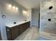 Bathroom showcasing a double vanity with dark cabinetry, modern lighting, and a walk-in shower at 1105 Oxeye St., North Myrtle Beach, SC 29582