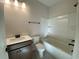 Well-lit bathroom with a vanity, toilet, and a bathtub with a shower and built-in shelves at 1105 Oxeye St., North Myrtle Beach, SC 29582