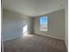 Cozy bedroom with neutral walls, plush carpet, and a window with a view of the outdoors at 1105 Oxeye St., North Myrtle Beach, SC 29582