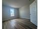 Light-filled bedroom with wood-look flooring, a large window, and neutral paint throughout at 1105 Oxeye St., North Myrtle Beach, SC 29582