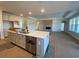 Open-concept kitchen with a large island, stainless steel appliances, and a view of the living area at 1105 Oxeye St., North Myrtle Beach, SC 29582