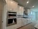 Modern kitchen featuring stainless steel appliances, including double oven and white cabinets at 1105 Oxeye St., North Myrtle Beach, SC 29582