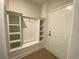 White mudroom with built-in storage, a bench seat, and coat hooks near the door at 1105 Oxeye St., North Myrtle Beach, SC 29582