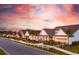 Street view of charming single-Gathering homes, manicured lawns, and colorful sunset sky at 1105 Oxeye St., North Myrtle Beach, SC 29582