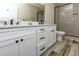 Elegant bathroom featuring a double vanity, white cabinets with dark hardware, and a glass-enclosed shower at 113-B 10Th Ave. S, Surfside Beach, SC 29575