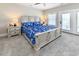Bright bedroom with neutral decor, a large bed with decorative linens, and balcony access at 113-B 10Th Ave. S, Surfside Beach, SC 29575