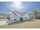 Rear view of home with a spacious driveway and a lush backyard at 1201 Ficus Dr., Myrtle Beach, SC 29579