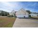 Inviting home featuring a three-car garage, well-manicured landscaping, and charming American flag at 1201 Ficus Dr., Myrtle Beach, SC 29579