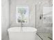 Elegant bathroom featuring a freestanding tub, a window, and marble-look tile at 1217 Bentcreek Ln., Myrtle Beach, SC 29579