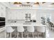 Bright eat-in kitchen features white cabinetry, marble countertops and backsplash, and seating for four at the kitchen island at 1217 Bentcreek Ln., Myrtle Beach, SC 29579