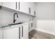 Bright laundry room featuring modern cabinetry, sink, and contemporary black hardware at 1217 Bentcreek Ln., Myrtle Beach, SC 29579