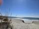 Picturesque beach view with gentle waves, sandy dunes, and the sun reflecting off the water at 1221 Tidewater Dr. # 1721, North Myrtle Beach, SC 29582