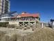 Exterior view of a charming beach house featuring a spacious deck and a red roof at 1221 Tidewater Dr. # 1721, North Myrtle Beach, SC 29582