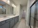 Bathroom featuring double sink vanity, tiled floors, and a glass-enclosed shower at 1229 Lady Bird Way, North Myrtle Beach, SC 29582