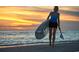 Person with paddle board on sandy beach near ocean at sunset after day of fun at 1229 Lady Bird Way, North Myrtle Beach, SC 29582