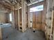 Bathroom space showing the framing, plumbing lines, concrete floor and window at 1229 Lady Bird Way, North Myrtle Beach, SC 29582