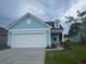 Charming single-story home featuring light blue siding and a white two-car garage under a cloudy sky at 1229 Lady Bird Way, North Myrtle Beach, SC 29582