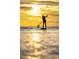 Scenic view of person paddle boarding on calm ocean waters during a vibrant golden sunset at 1229 Lady Bird Way, North Myrtle Beach, SC 29582