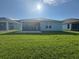 A large backyard has a covered porch and ample green grass at 1249 Crested Iris Way, North Myrtle Beach, SC 29582