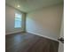 A bedroom with dark hardwood floors and a large window providing an abundance of light at 1249 Crested Iris Way, North Myrtle Beach, SC 29582