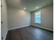 Empty bedroom with dark hardwood floors and a single window allowing lots of natural light at 1249 Crested Iris Way, North Myrtle Beach, SC 29582